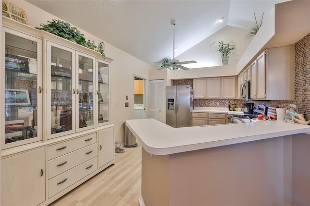 1111 Golfview Woods Dr Unit 1111, Sun City Center, FL 33573 - kitchen featuring stainless steel appliances, light wood finished floors, light countertops, a peninsula, and high vaulted ceiling