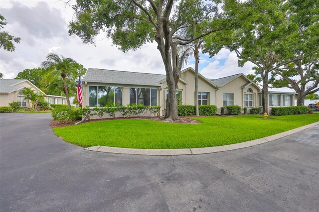 1111 Golfview Woods Dr Unit 1111, Sun City Center, FL 33573 - ranch-style house featuring stucco siding and a front lawn