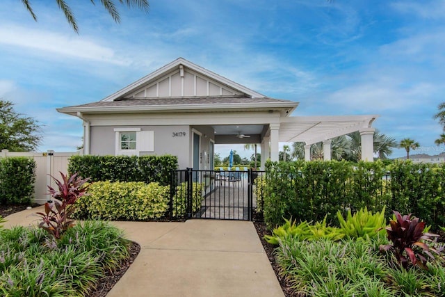 34234 Polacca Ln, Wesley Chapel, FL 33543 - view of front of property with a gate, ceiling fan, board and batten siding, stucco siding, and a pergola