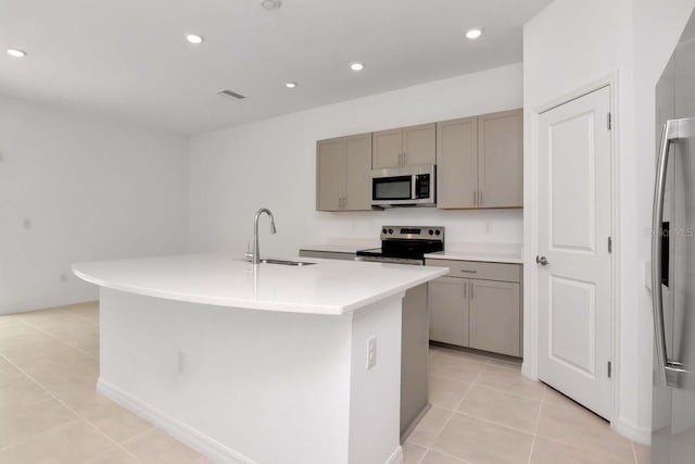 34234 Polacca Ln, Wesley Chapel, FL 33543 - kitchen with appliances with stainless steel finishes, gray cabinetry, light tile patterned flooring, a kitchen island with sink, and recessed lighting