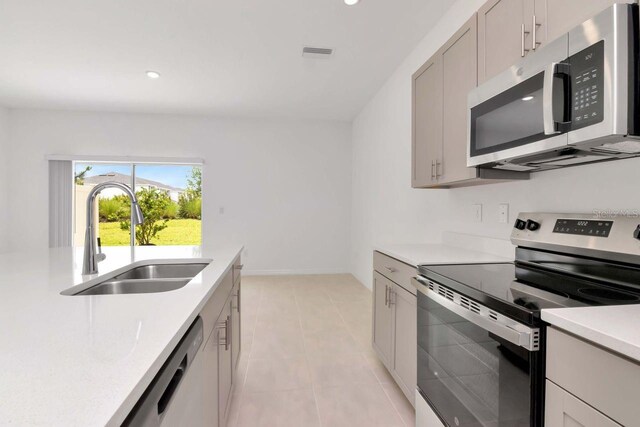 34234 Polacca Ln, Wesley Chapel, FL 33543 - kitchen featuring stainless steel appliances, light countertops, light tile patterned floors, gray cabinetry, and recessed lighting