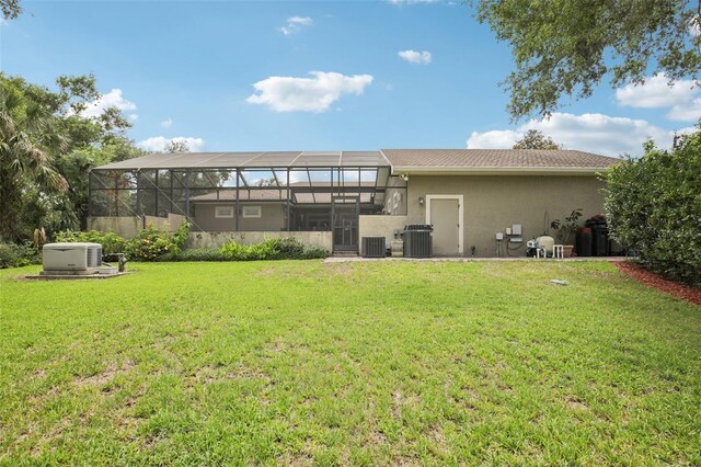 1803 143rd Ct E, Bradenton, FL 34212 - rear view of house featuring central AC unit, a yard, stucco siding, and glass enclosure