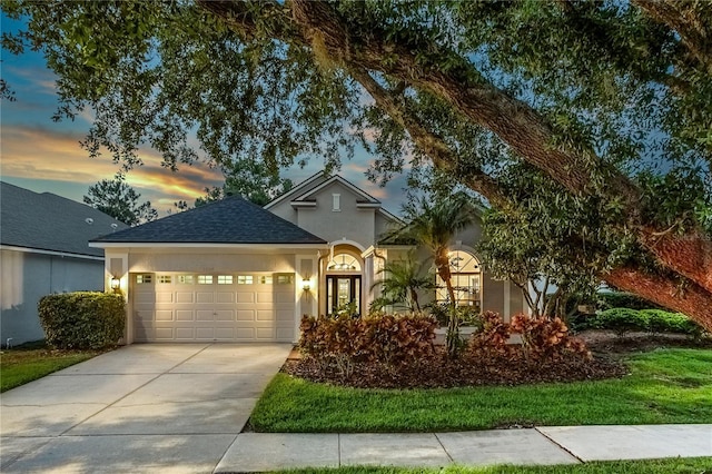 9608 Greenpointe Dr, Tampa, FL 33626 - view of front facade with stucco siding, a garage, concrete driveway, and roof with shingles