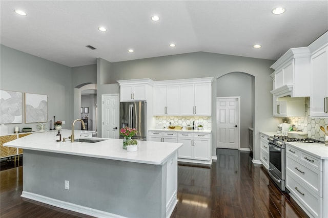 9608 Greenpointe Dr, Tampa, FL 33626 - kitchen with arched walkways, appliances with stainless steel finishes, a sink, backsplash, and white cabinetry