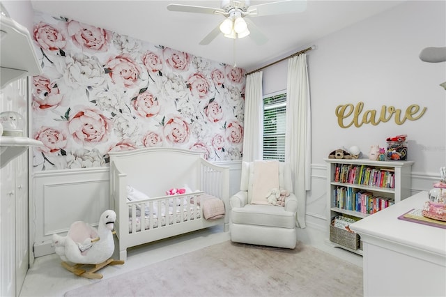 9608 Greenpointe Dr, Tampa, FL 33626 - bedroom featuring a nursery area, a decorative wall, a ceiling fan, and a wainscoted wall