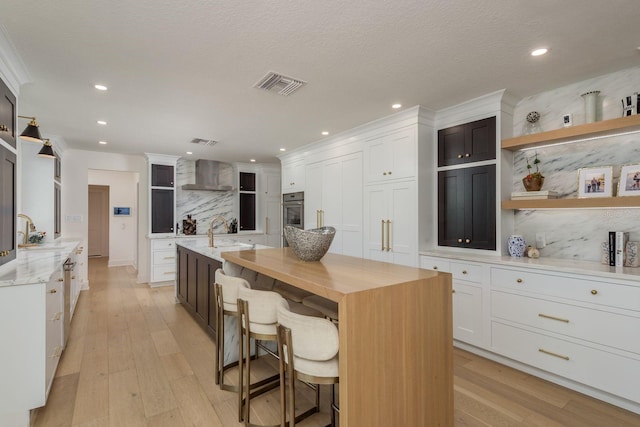 2395 Campbell Rd, Clearwater, FL 33765 - kitchen with open shelves, a sink, wall chimney exhaust hood, tasteful backsplash, and a large island