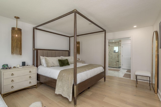 2395 Campbell Rd, Clearwater, FL 33765 - bedroom featuring light wood finished floors, recessed lighting, ensuite bath, and a textured ceiling
