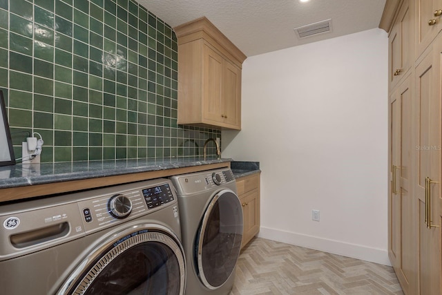 2395 Campbell Rd, Clearwater, FL 33765 - laundry area featuring washing machine and clothes dryer, cabinet space, baseboards, and a textured ceiling