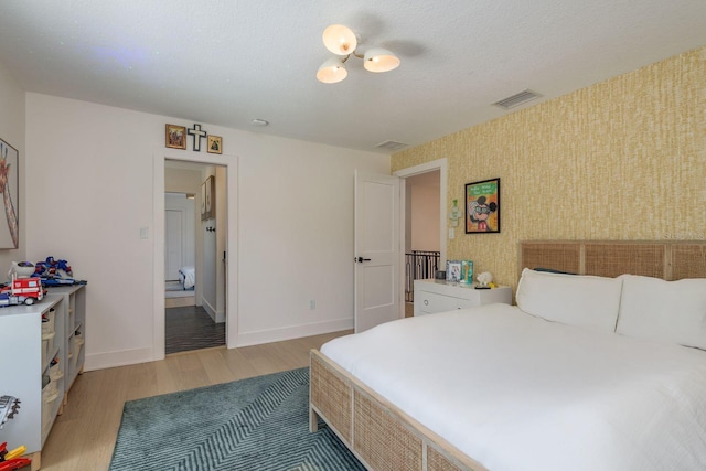 2395 Campbell Rd, Clearwater, FL 33765 - bedroom with wallpapered walls, light wood-style flooring, and baseboards
