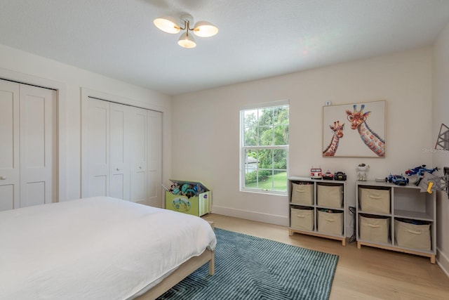2395 Campbell Rd, Clearwater, FL 33765 - bedroom featuring two closets, light wood-type flooring, and baseboards