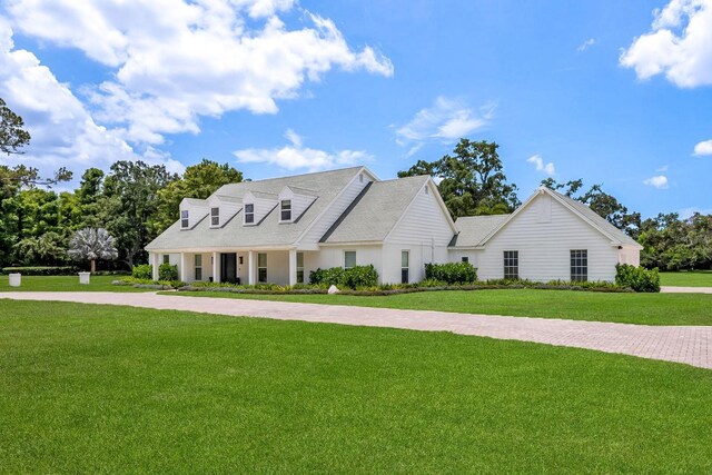 2395 Campbell Rd, Clearwater, FL 33765 - cape cod house featuring a front lawn and roof with shingles
