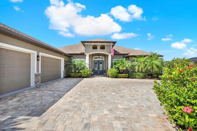15415 Mulholland Rd, Parrish, FL 34219 - mediterranean / spanish-style home featuring stucco siding, an attached garage, and decorative driveway