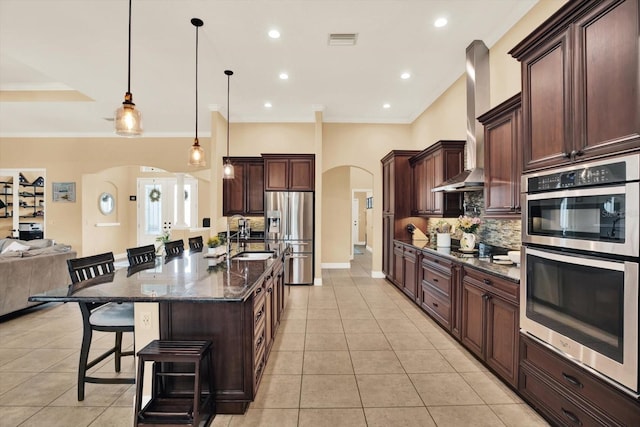 15415 Mulholland Rd, Parrish, FL 34219 - kitchen with arched walkways, appliances with stainless steel finishes, a sink, a breakfast bar, and tasteful backsplash