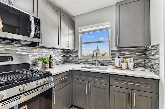 2960 59th St S Unit 303, Gulfport, FL 33707 - kitchen featuring appliances with stainless steel finishes, a sink, gray cabinetry, and backsplash
