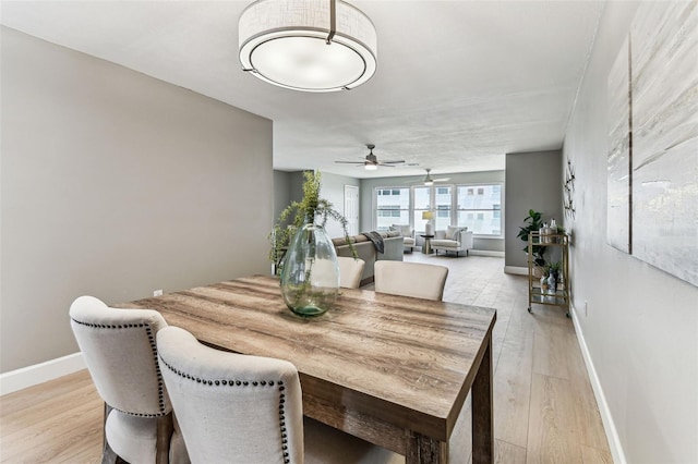 2960 59th St S Unit 303, Gulfport, FL 33707 - dining area featuring a ceiling fan, light wood-style flooring, and baseboards