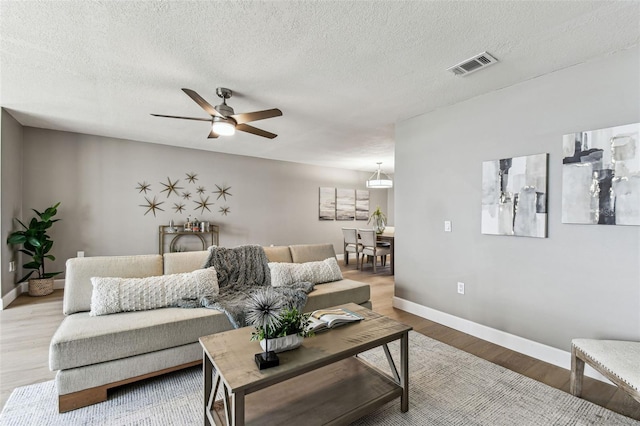 2960 59th St S Unit 303, Gulfport, FL 33707 - living area featuring a ceiling fan, baseboards, wood finished floors, and a textured ceiling