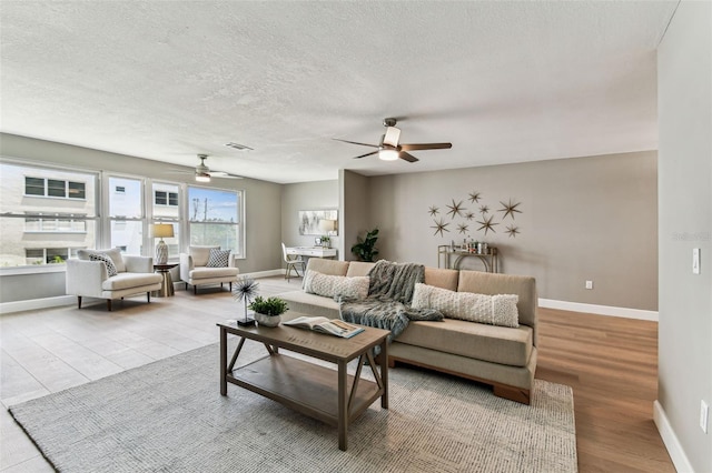 2960 59th St S Unit 303, Gulfport, FL 33707 - living area with a ceiling fan, baseboards, wood finished floors, and a textured ceiling