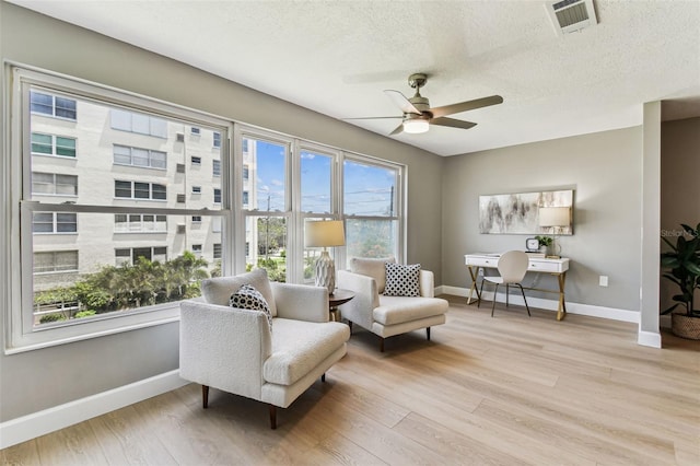 2960 59th St S Unit 303, Gulfport, FL 33707 - sitting room with baseboards, wood finished floors, a ceiling fan, and a textured ceiling
