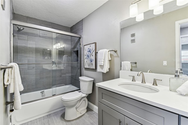2960 59th St S Unit 303, Gulfport, FL 33707 - full bath with vanity, toilet, shower / bath combination with glass door, baseboards, and wood finished floors