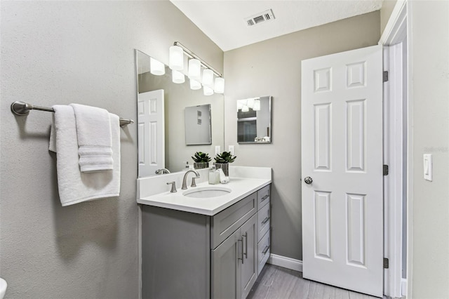 2960 59th St S Unit 303, Gulfport, FL 33707 - bathroom featuring vanity, baseboards, and wood finished floors