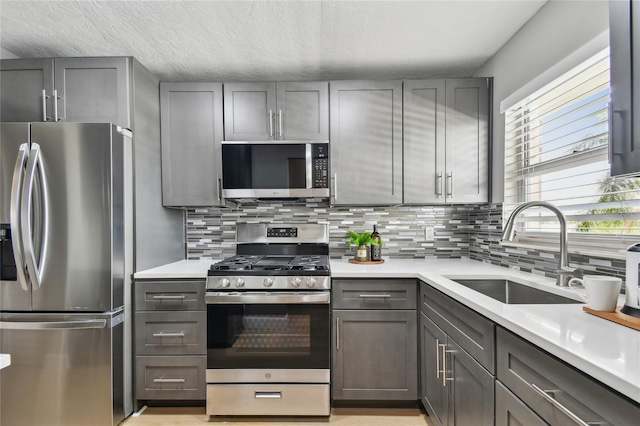 2960 59th St S Unit 303, Gulfport, FL 33707 - kitchen featuring appliances with stainless steel finishes, gray cabinetry, decorative backsplash, and light countertops