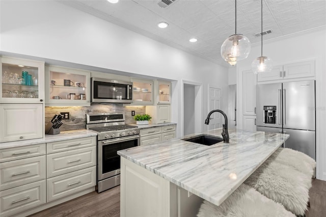 146 26th Ave NE, Saint Petersburg, FL 33704 - kitchen featuring appliances with stainless steel finishes, a sink, ornamental molding, dark wood finished floors, and decorative backsplash