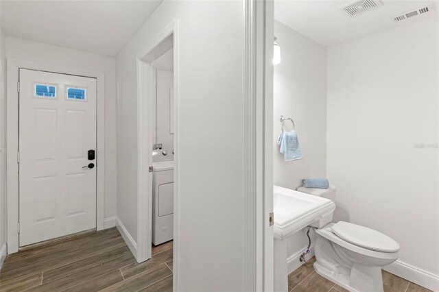 146 26th Ave NE, Saint Petersburg, FL 33704 - bathroom featuring wood finish floors, washer / dryer, toilet, and baseboards