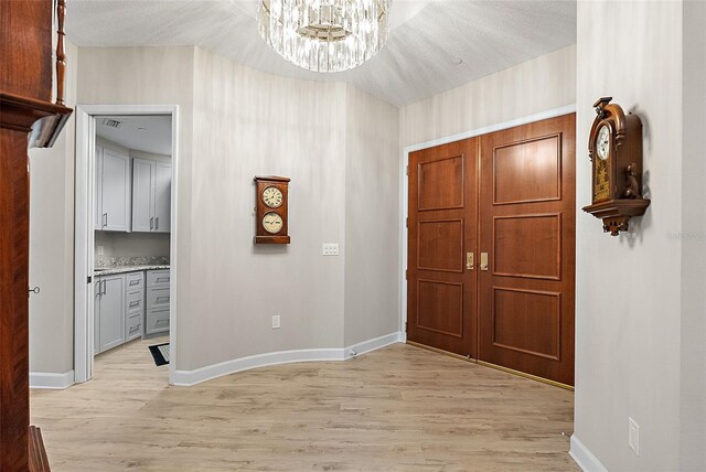 100 Beach Dr NE Unit 301, Saint Petersburg, FL 33701 - foyer entrance featuring light wood-style floors, a chandelier, and baseboards