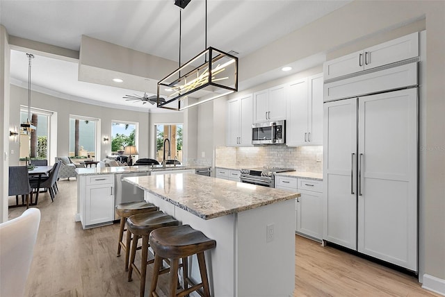 100 Beach Dr NE Unit 301, Saint Petersburg, FL 33701 - kitchen featuring appliances with stainless steel finishes, a peninsula, a chandelier, light wood-type flooring, and recessed lighting