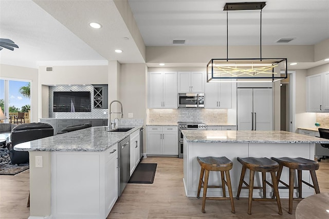 100 Beach Dr NE Unit 301, Saint Petersburg, FL 33701 - kitchen with stainless steel appliances, a sink, decorative backsplash, light wood finished floors, and recessed lighting