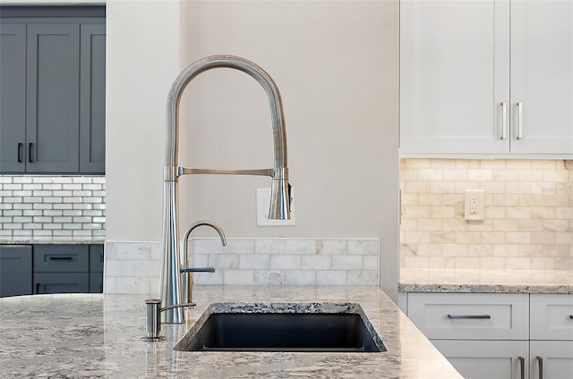 100 Beach Dr NE Unit 301, Saint Petersburg, FL 33701 - kitchen with backsplash, a sink, and white cabinetry