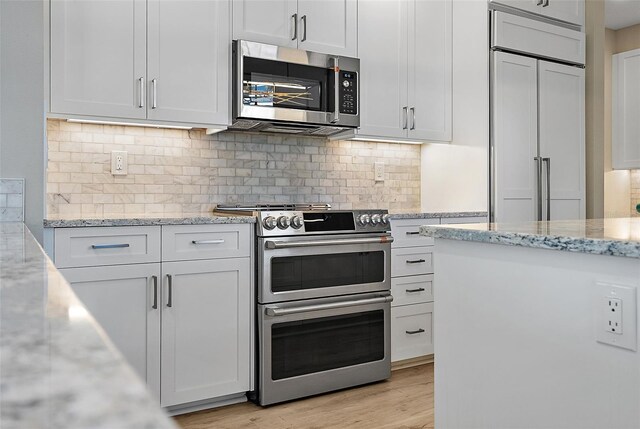 100 Beach Dr NE Unit 301, Saint Petersburg, FL 33701 - kitchen with stainless steel appliances, white cabinets, and light wood finished floors