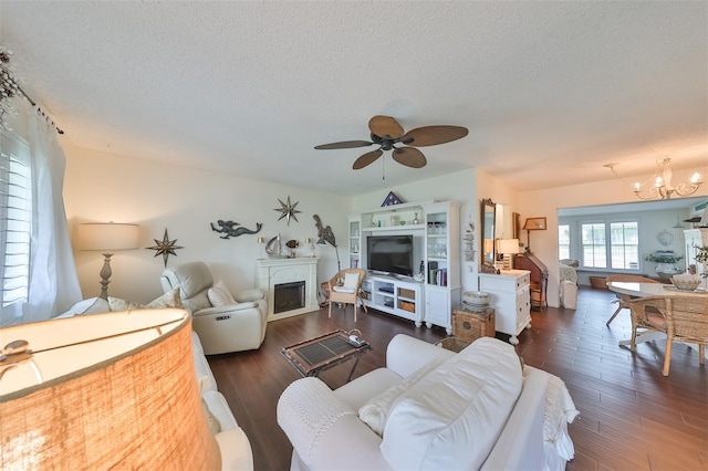 1224 W Del Webb Blvd, Sun City Center, FL 33573 - living room with a fireplace, dark wood-style flooring, ceiling fan, a textured ceiling, and a chandelier