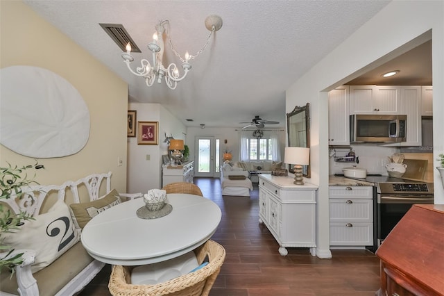 1224 W Del Webb Blvd, Sun City Center, FL 33573 - dining area with dark wood-type flooring, a chandelier, a textured ceiling, and a ceiling fan