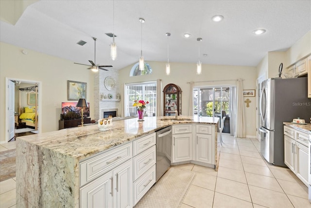 4047 Eagle Cove W Dr, Palm Harbor, FL 34685 - kitchen with vaulted ceiling, a ceiling fan, light tile patterned floors, stainless steel appliances, and a large fireplace