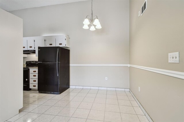 3389 Crystal Ct E J, Unit J, Palm Harbor, FL 34685 - kitchen with black appliances, under cabinet range hood, white cabinetry, a chandelier, and light tile patterned flooring