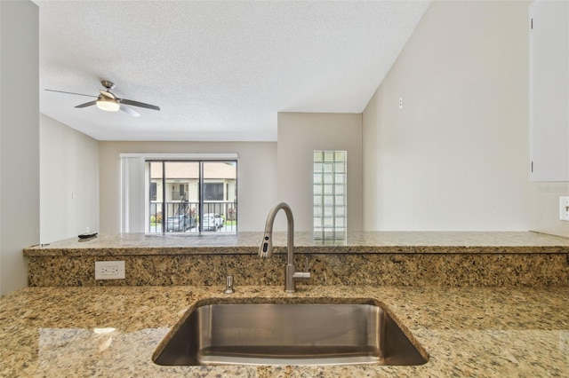 3389 Crystal Ct E J, Unit J, Palm Harbor, FL 34685 - kitchen featuring a sink, light stone counters, ceiling fan, and a textured ceiling