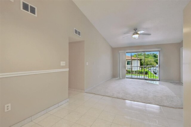 3389 Crystal Ct E J, Unit J, Palm Harbor, FL 34685 - empty room featuring a ceiling fan, light colored carpet, vaulted ceiling, baseboards, and light tile patterned floors