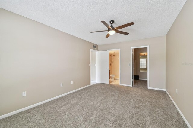 3389 Crystal Ct E J, Unit J, Palm Harbor, FL 34685 - unfurnished bedroom with carpet flooring, connected bathroom, a textured ceiling, baseboards, and a ceiling fan