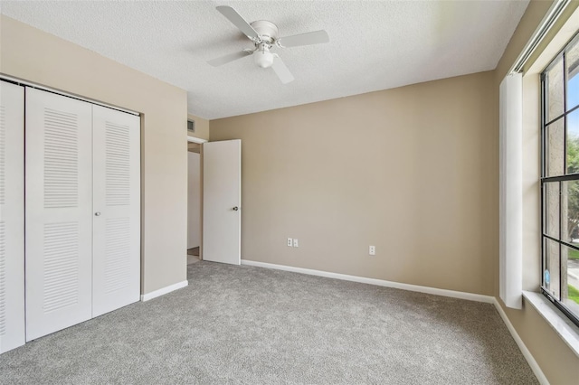 3389 Crystal Ct E J, Unit J, Palm Harbor, FL 34685 - unfurnished bedroom featuring carpet, a closet, a textured ceiling, ceiling fan, and baseboards