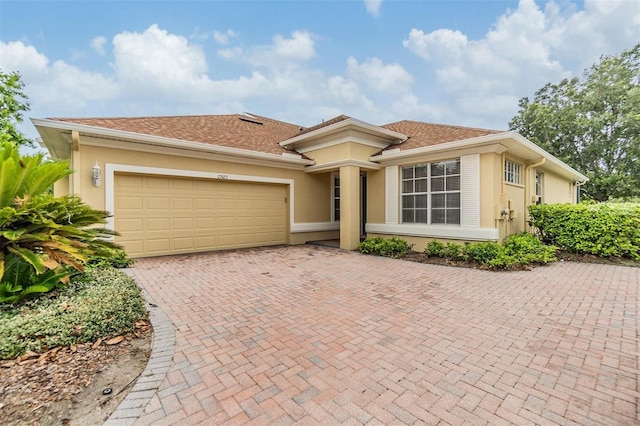 27427 Mistflower Dr, Wesley Chapel, FL 33544 - view of front of house with stucco siding, an attached garage, and decorative driveway