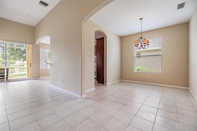 27427 Mistflower Dr, Wesley Chapel, FL 33544 - unfurnished room with light tile patterned flooring, arched walkways, a chandelier, and baseboards