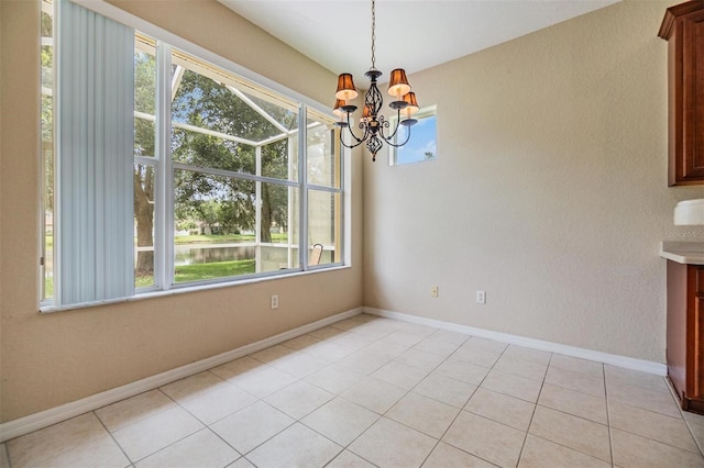 27427 Mistflower Dr, Wesley Chapel, FL 33544 - unfurnished dining area featuring plenty of natural light, a chandelier, baseboards, and light tile patterned floors