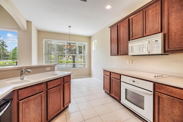 27427 Mistflower Dr, Wesley Chapel, FL 33544 - kitchen with white appliances, a sink, plenty of natural light, light tile patterned floors, and recessed lighting