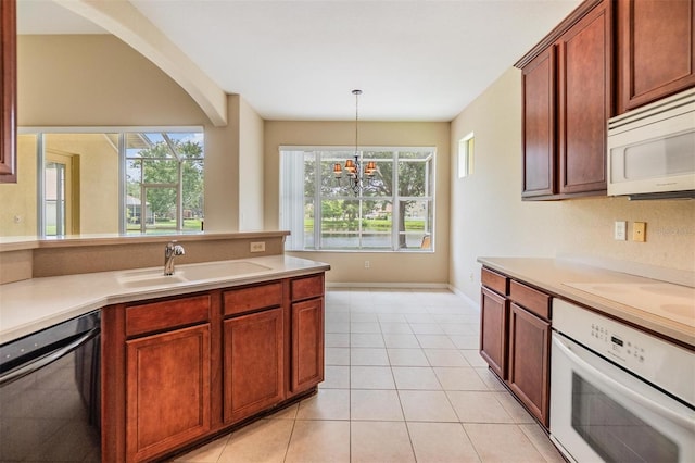 27427 Mistflower Dr, Wesley Chapel, FL 33544 - kitchen featuring white appliances, a sink, light countertops, and a chandelier