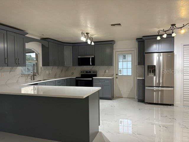 6820 26th St W, Bradenton, FL 34207 - kitchen with appliances with stainless steel finishes, decorative backsplash, arched walkways, and a peninsula
