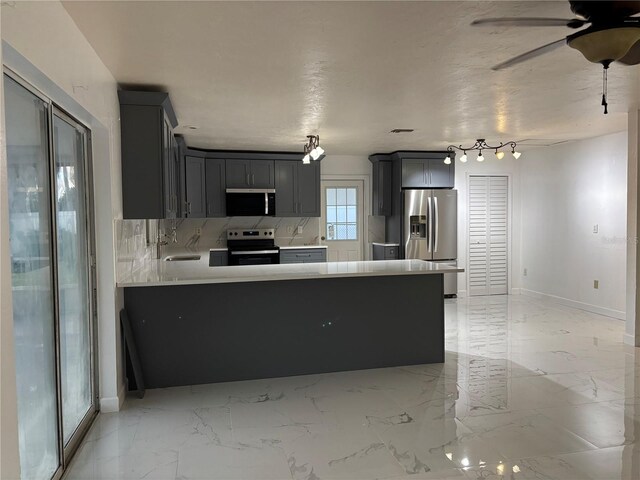 6820 26th St W, Bradenton, FL 34207 - kitchen with appliances with stainless steel finishes, a peninsula, ceiling fan, light countertops, and backsplash