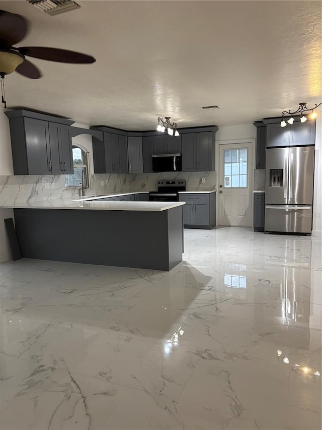 6820 26th St W, Bradenton, FL 34207 - kitchen featuring stainless steel appliances, backsplash, a peninsula, ceiling fan, and gray cabinets