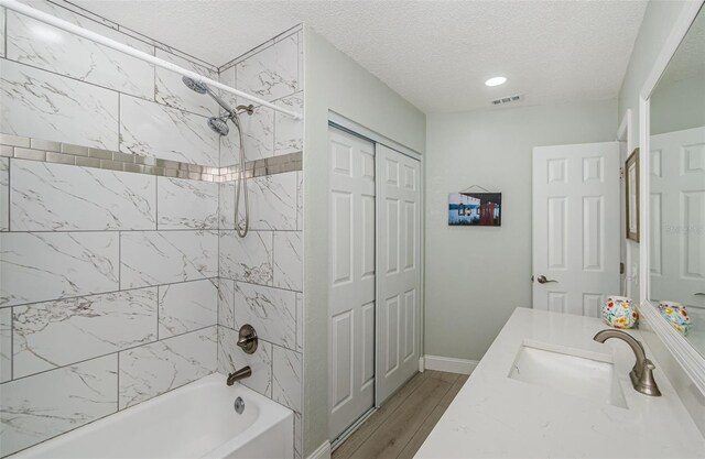7547 Landmark Dr, Spring Hill, FL 34606 - bathroom featuring shower / bath combination, vanity, a textured ceiling, and wood finished floors