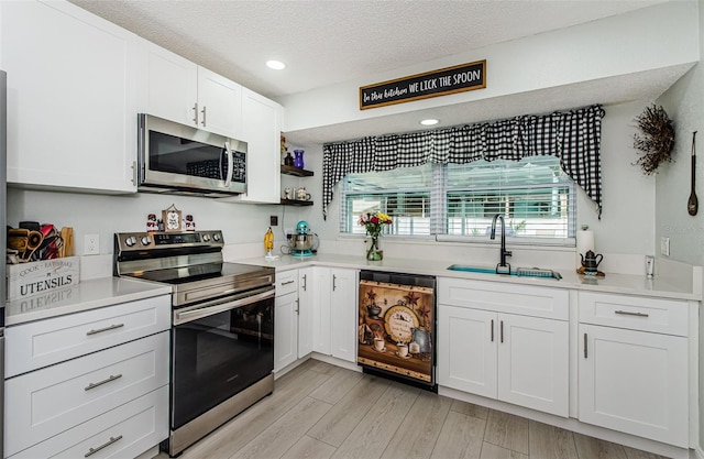 7547 Landmark Dr, Spring Hill, FL 34606 - kitchen featuring stainless steel appliances, healthy amount of natural light, white cabinets, a textured ceiling, and light countertops